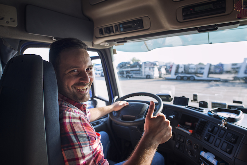 portrait truck driver sitting his truck holding thumbs up